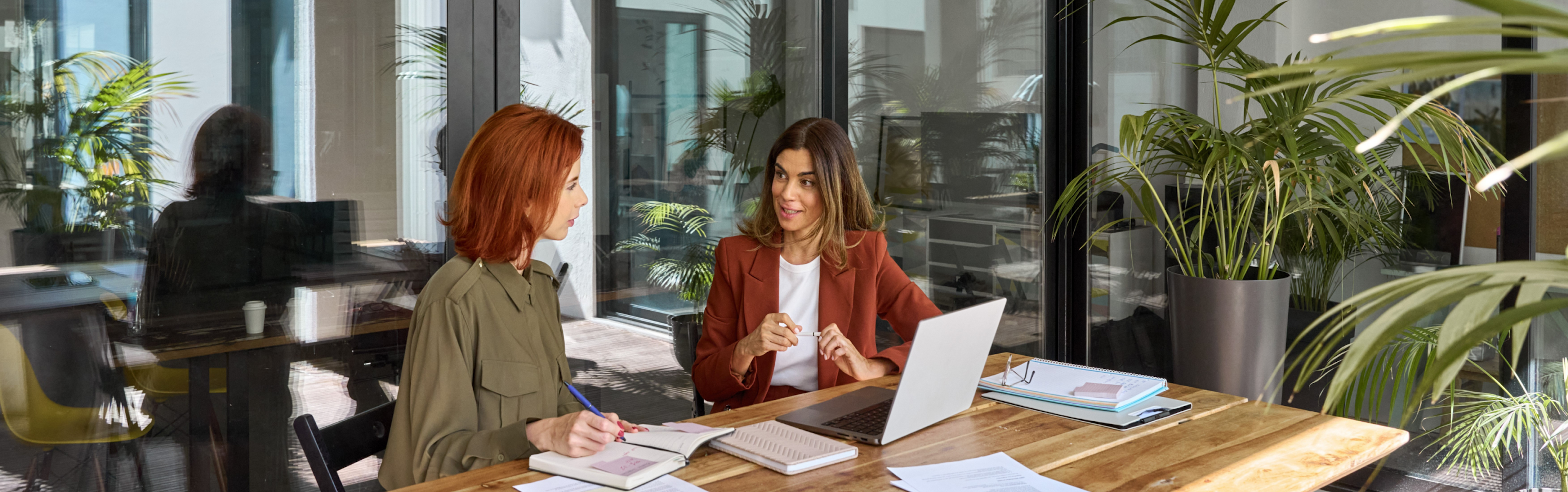 Two women sitting in office and discussing