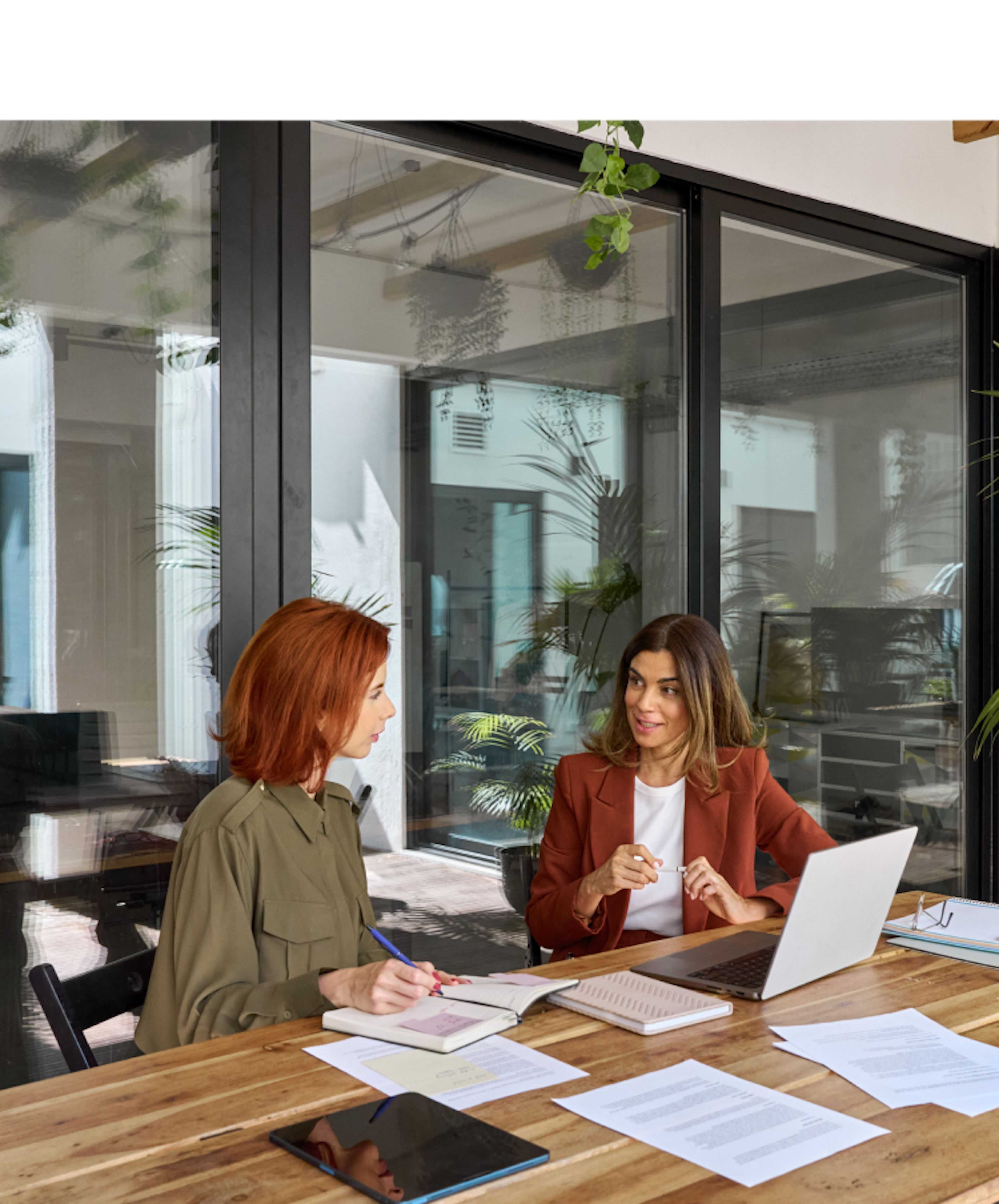 Two women sitting in office and discussing