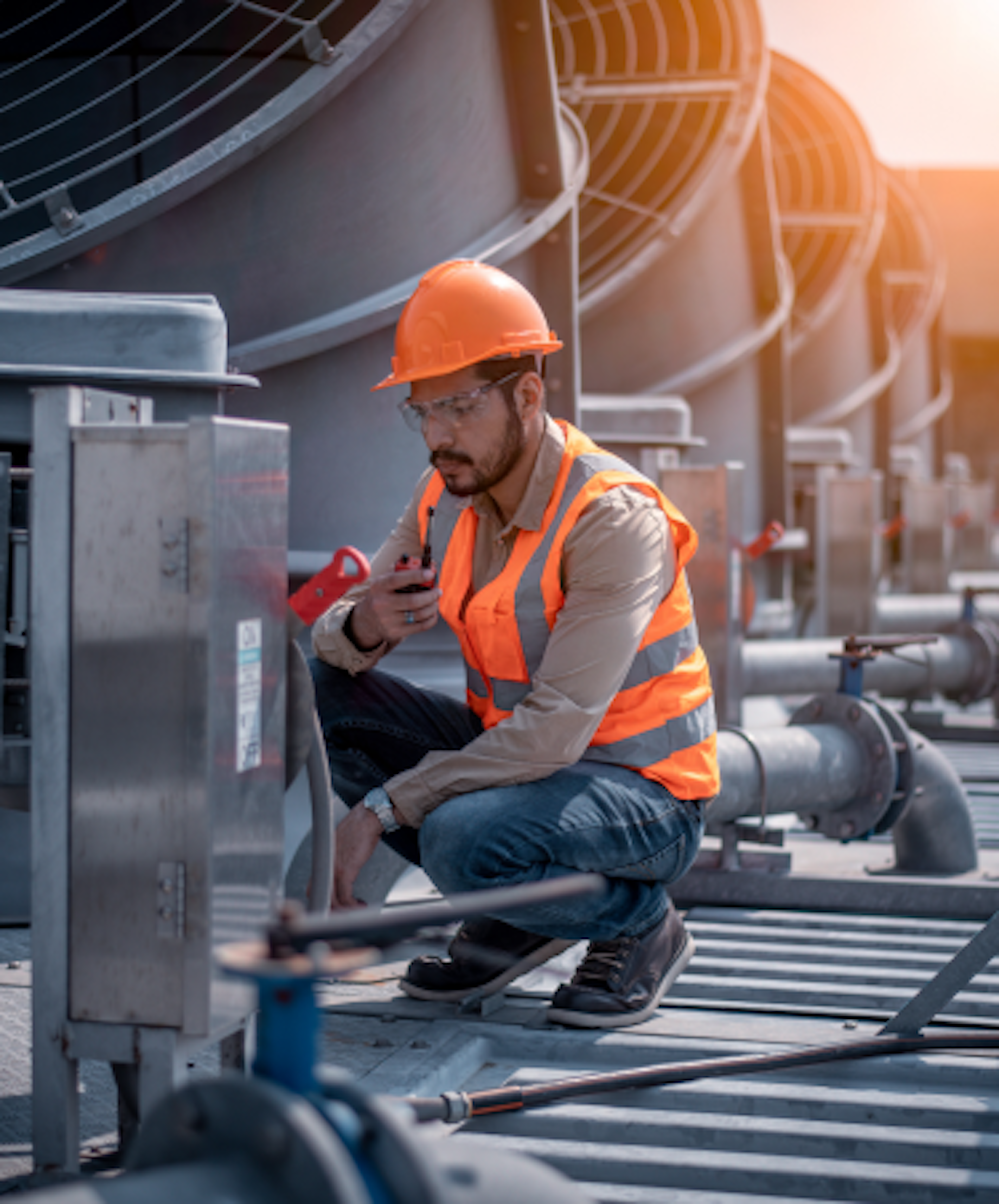 A person wearing safety gear working on heavy machenery